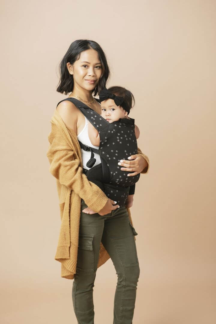 Mum wearing a toddler in a ergonomic travel baby carrier.