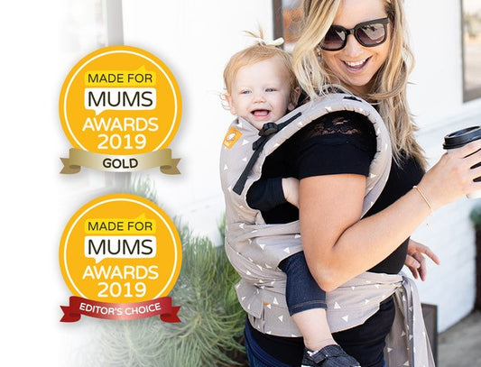 A mother and her child in back-carry position next to the two made for mums awards 2019