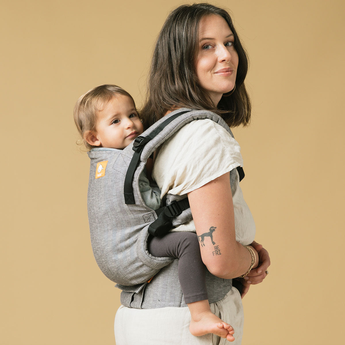 Mum babywearing her child on her back in Tula Free-to-Grow carrier