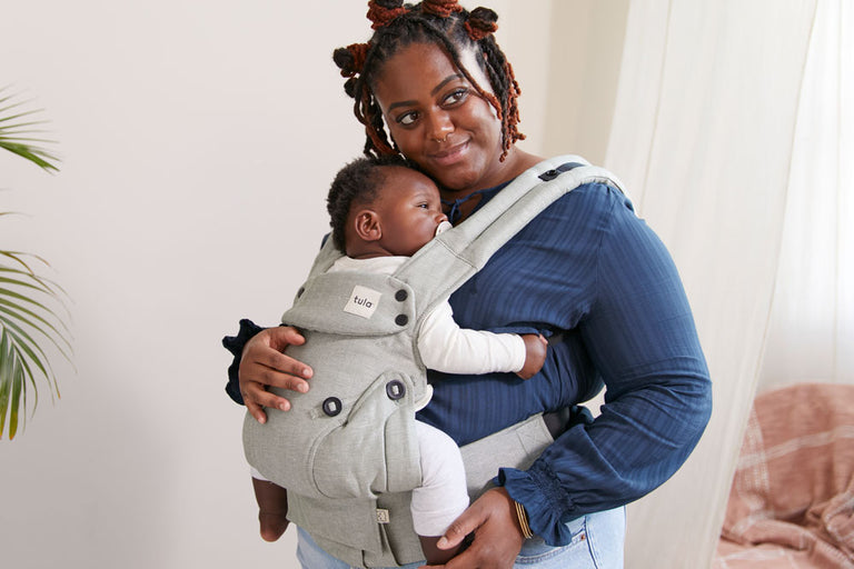Mum carrying her baby in Tula Explore Spruce baby carrier