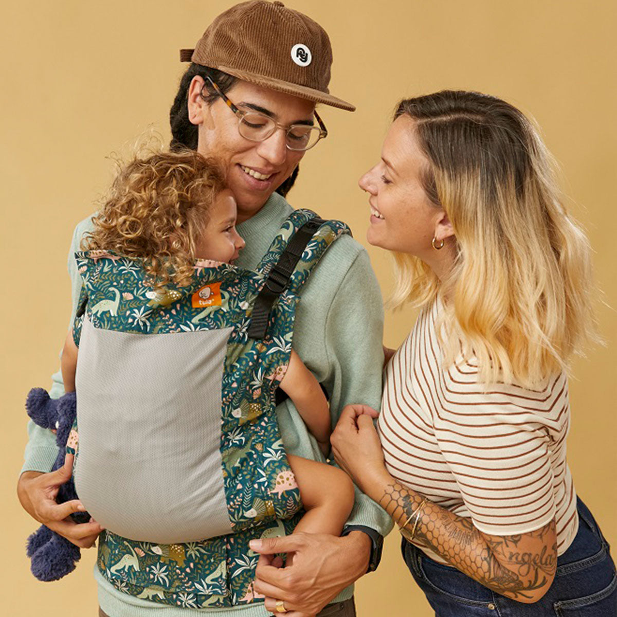 A couple with their child in Tula Toddler carrier sitting in inward facing position