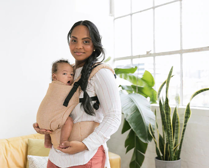 A mother and her sleepy baby using a Tula Linen Carrier.