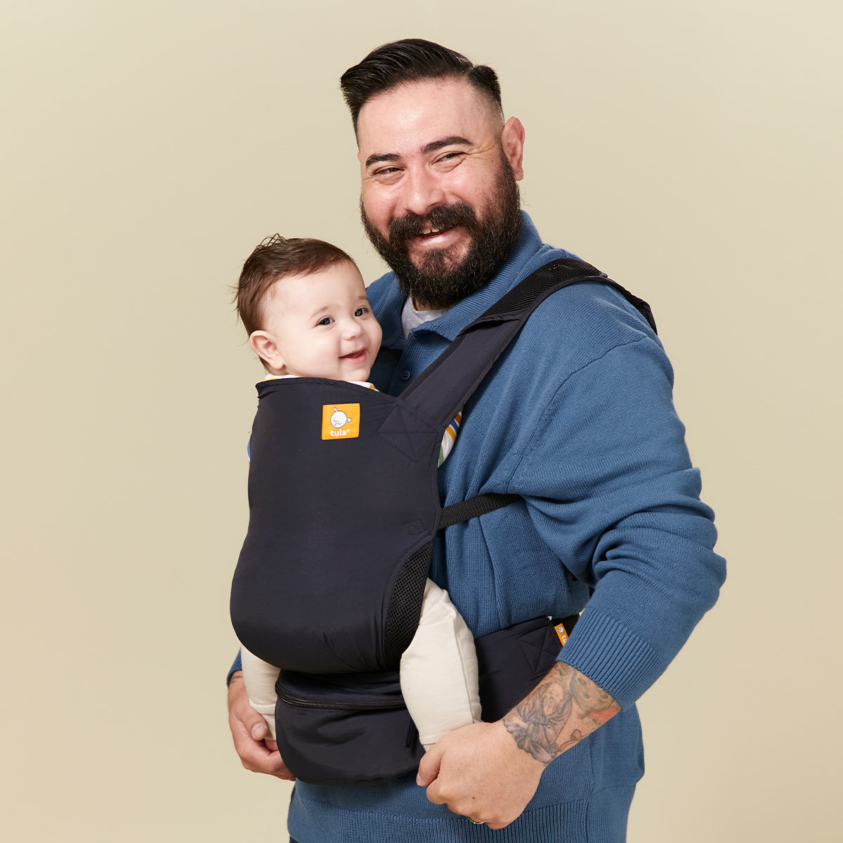 Happy dad with his child in Tula Lite carrier in inward facing position