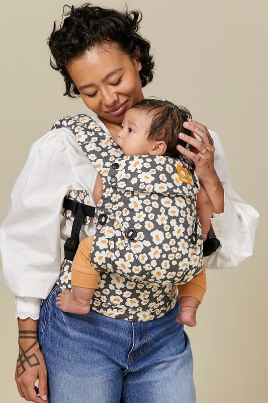 Tula Explore Baby Carrier with floral print over a dark background