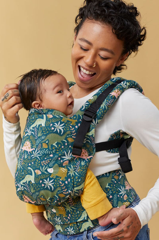 Tula Free-to-Grow Carrier Land Before Tula with a dinosaur print in emerald green and apricot.