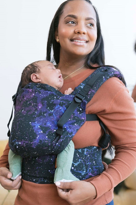 A baby sitting in the ergonomic Free-to-Grow Carrier Andromeda while sleeping.