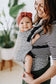 A mother who is carrying her child in the Coast Beyond Free-to-Grow Baby Carrier in front-carry position.