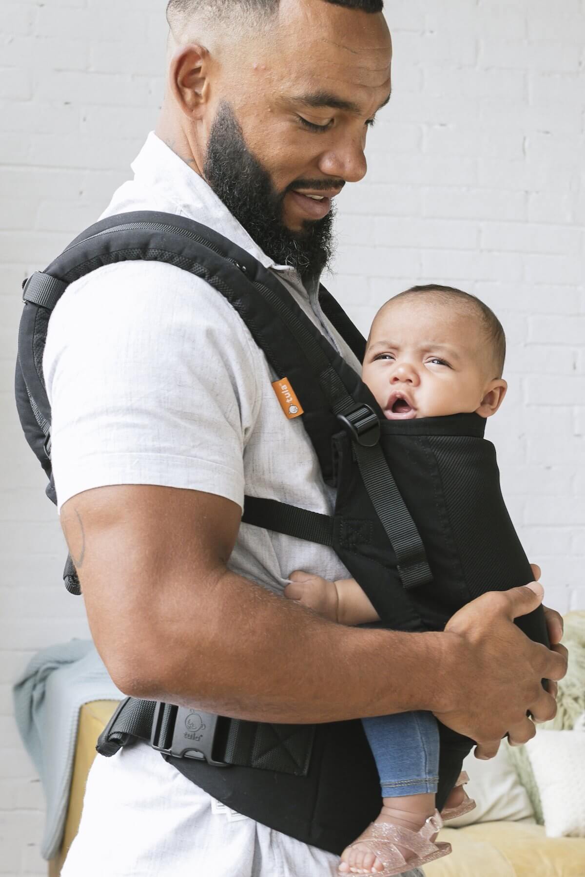 A father carrying his child in the Free-to-Grow Coast Urbanista Baby Carrier in front-carry position.