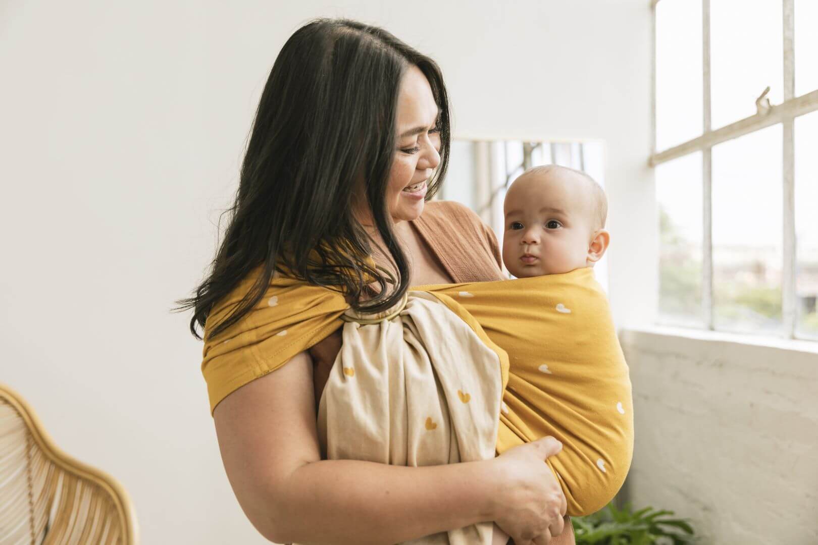 Curious baby in an ergonomic baby sling carrier.