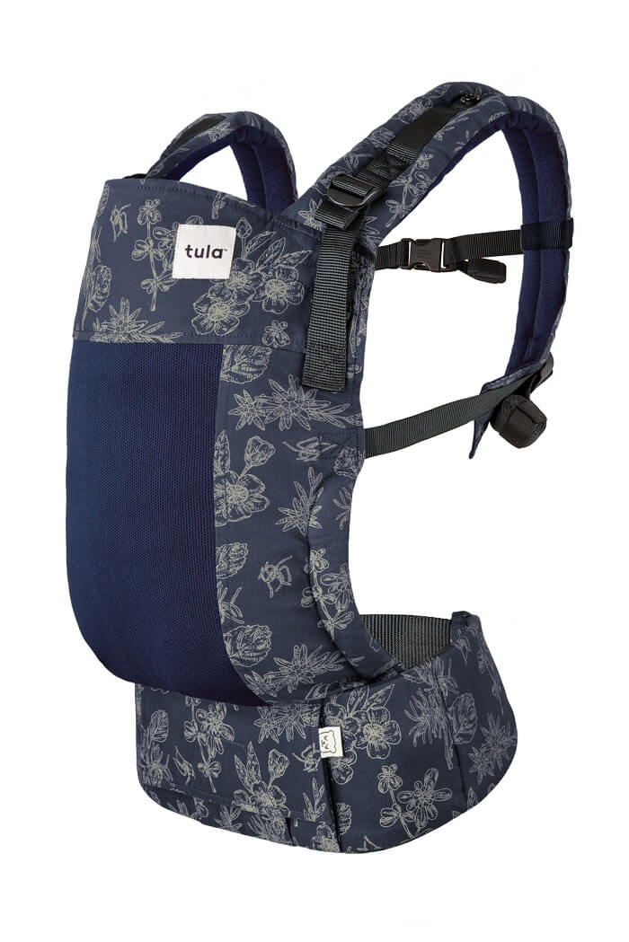 Tula Baby Carrier Coast Edelweiss with beige stenciled flowers on a navy blue background. 
