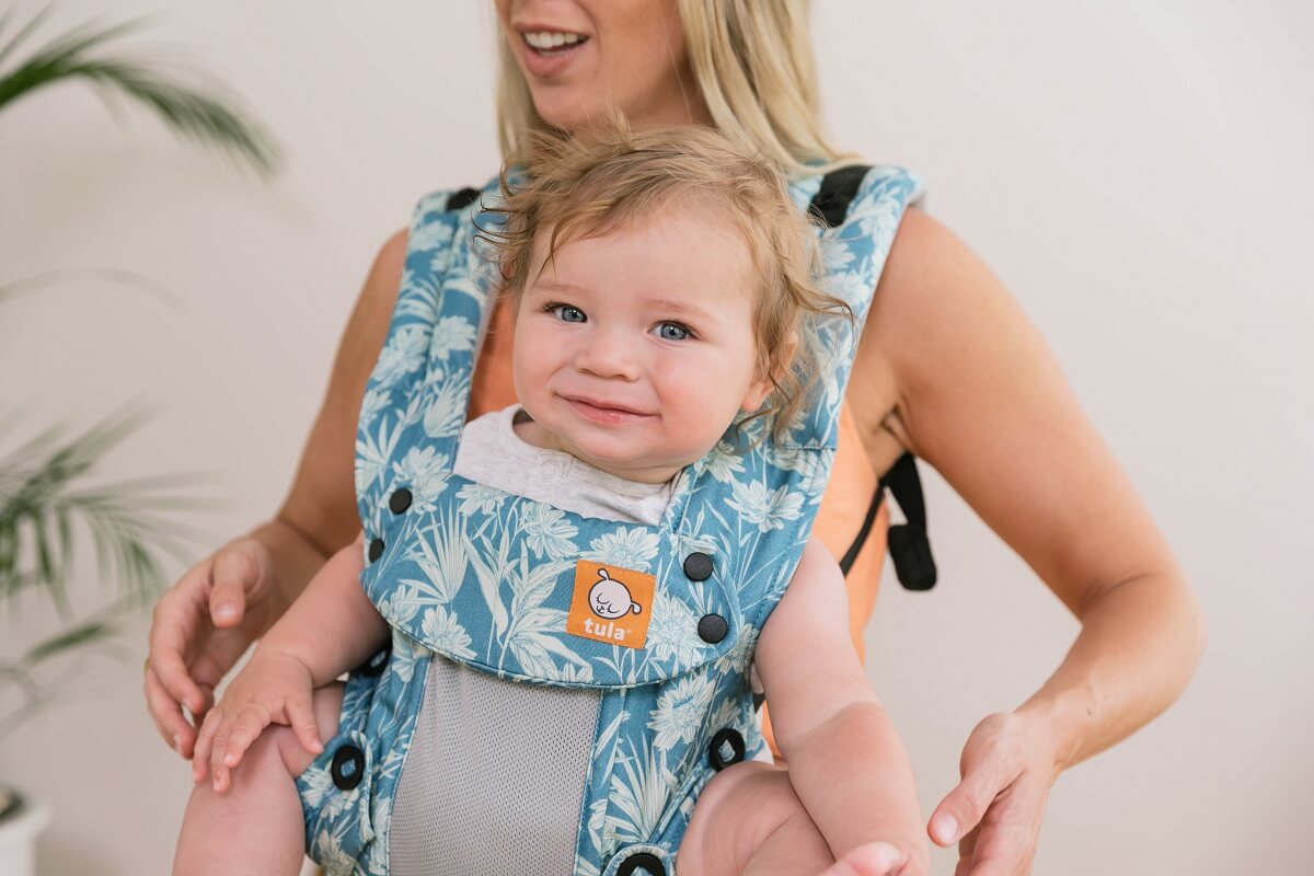 Closeup of an infant being worn in front carry position in an ergonomic baby carrier from birth