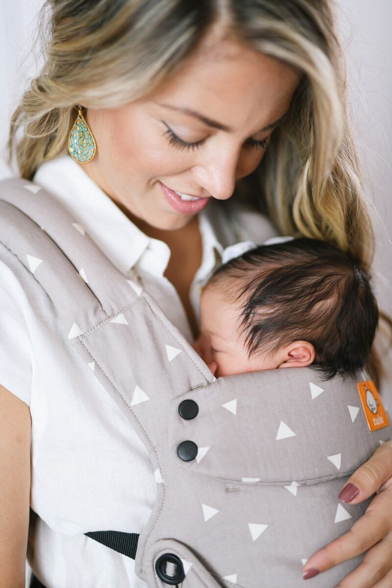 A closeup of a baby sleeping in the Explore Carrier Sleepy Dust in front-carry position.