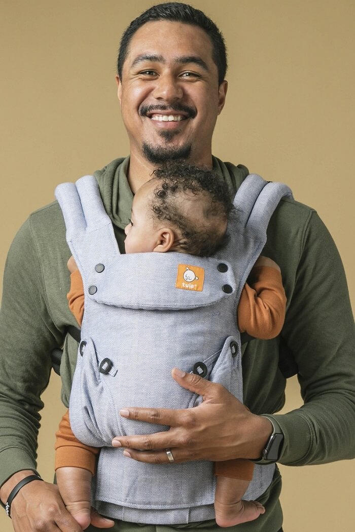 Caregiver wearing an Ergonomic Baby Carrier from Birth.
