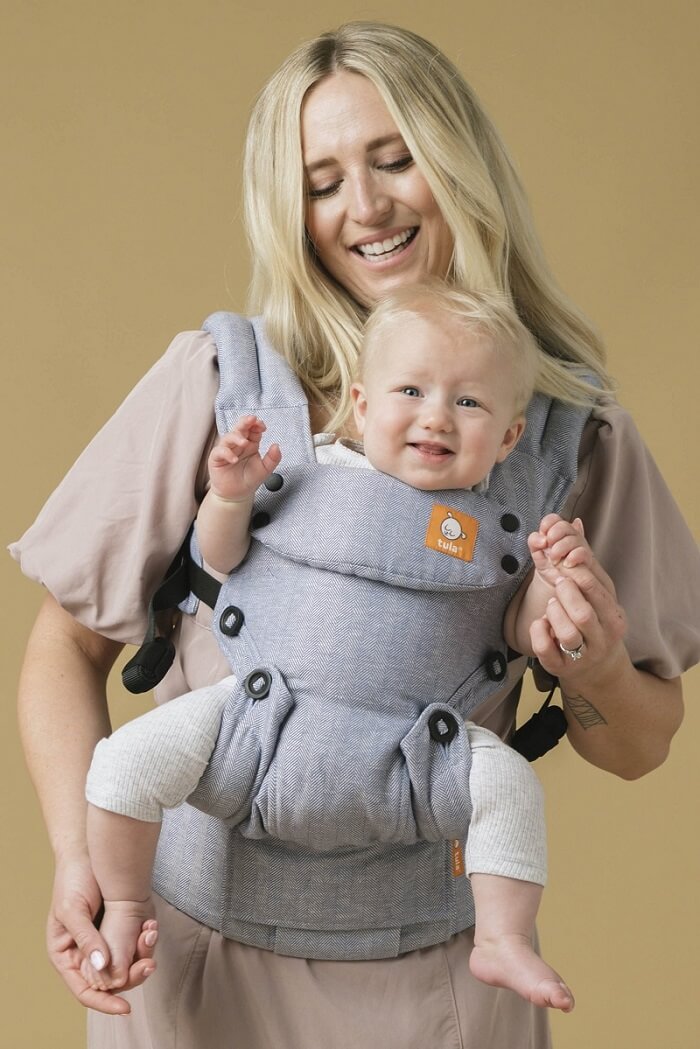 Front view of an ergonomic outward facing baby carrier.