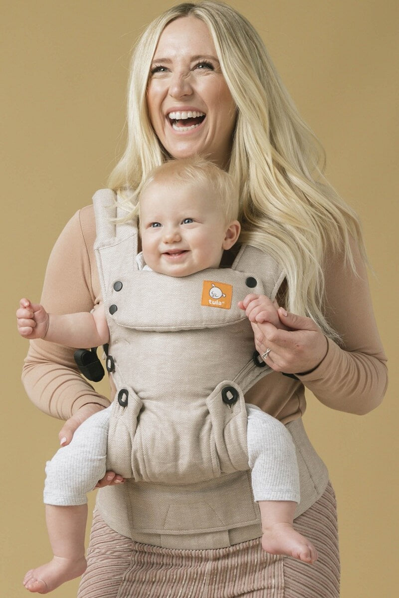 Front view of an ergonomic outward-facing baby carrier.