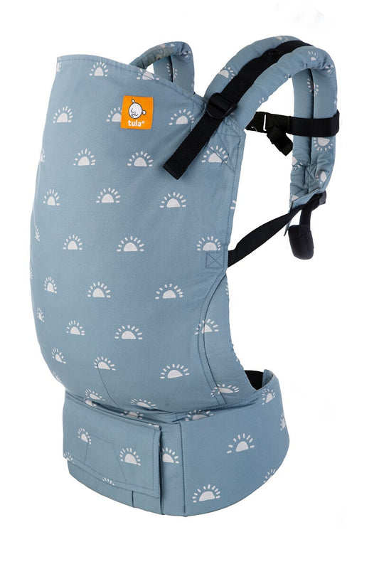 Tula Toddler Carrier Harbor Skies, colored in light blue with a repeating sunrise illustration in a light color.