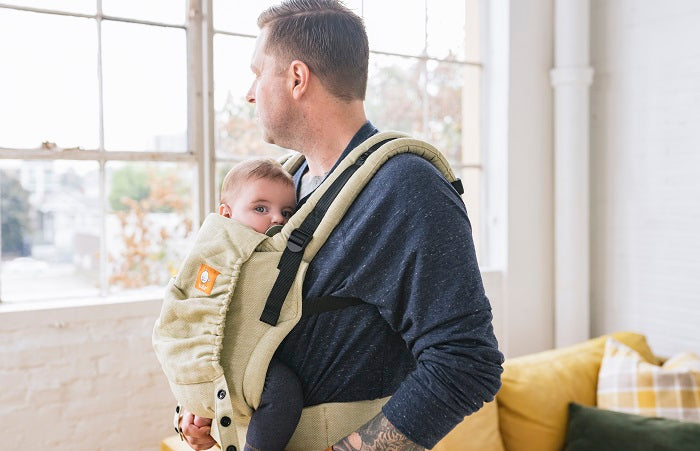 A father carrying his baby in an ergonomic Free-to-Grow Baby Carrier Linen Moss from Tula.