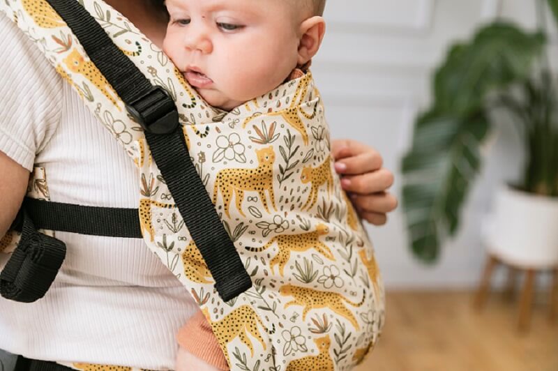 Baby sitting in an ergonomic Free-to-Grow Baby Carrier Prowl.