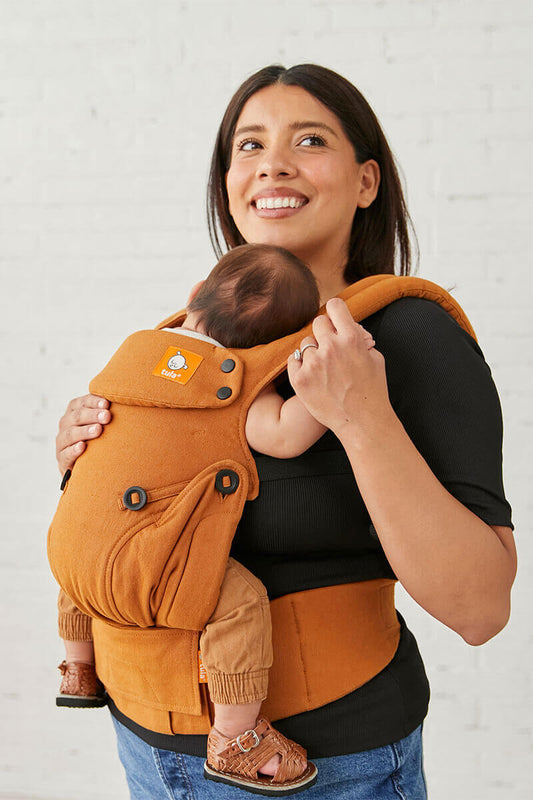 sideview of caregiver with a resting baby in a belly-to-belly position in an ergonomic soft baby carrier from birth made from hemp