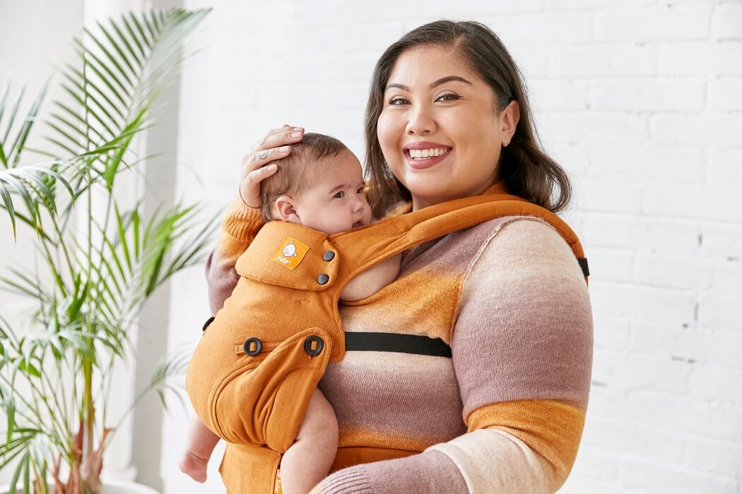 Caregiver wearing a soft Ergonomic Baby Carrier made from hemp in an inward-facing carry position