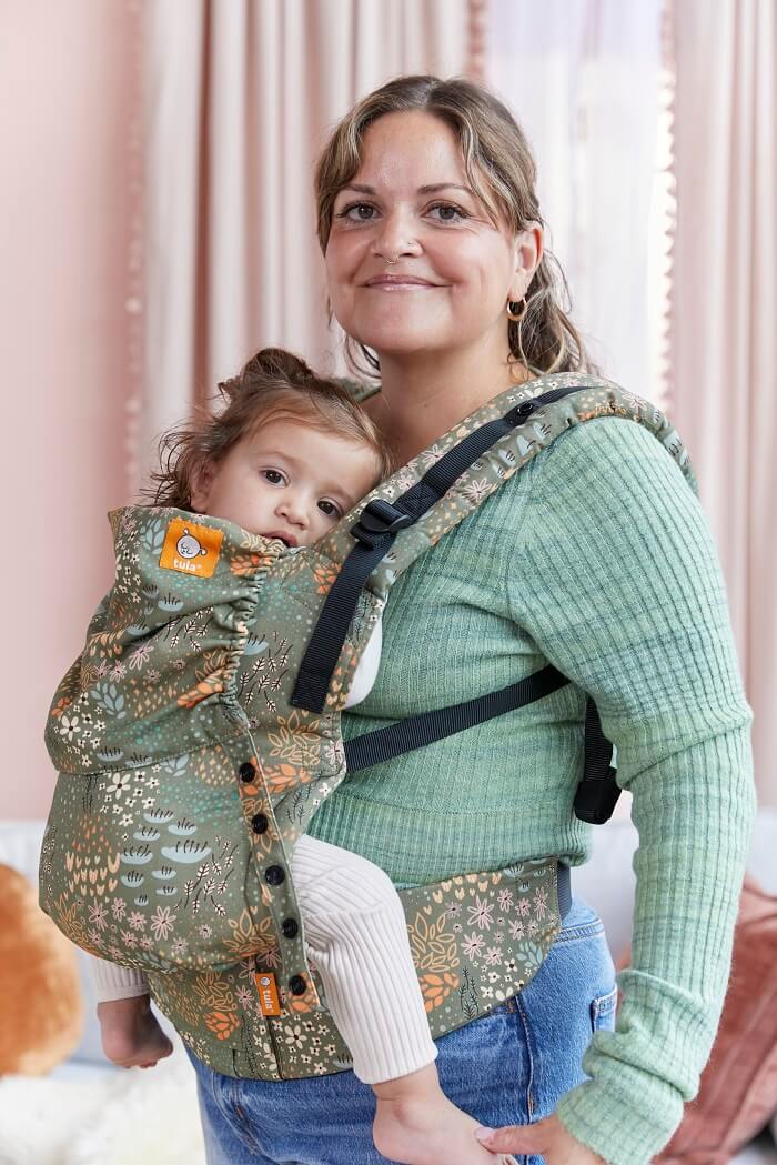 Baby resting on her mother's chest in inward facing position in Tula Free-to-Grow Baby Carrier Meadow