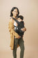 Mum wearing a toddler in a ergonomic travel baby carrier.