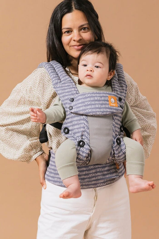 A baby sitting in the ergonomic Coast Beyond Explore Carrier in forward-facing position.