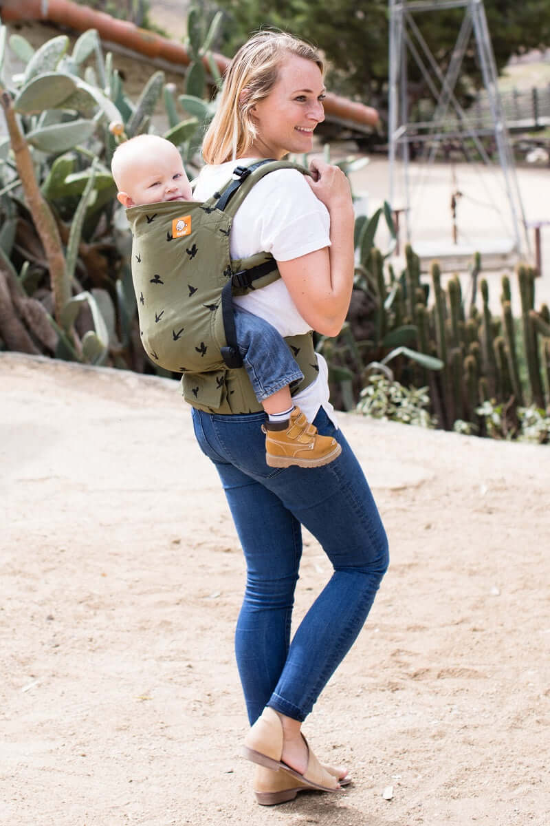 A mother explore outside togther with her toddler who is sitting in the ergonomic Toddler Carrier Soar in back-carry position.
